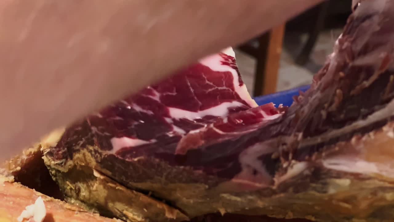 disparo de cerca del chef cortando cuidadosamente carne roja cruda fresca
