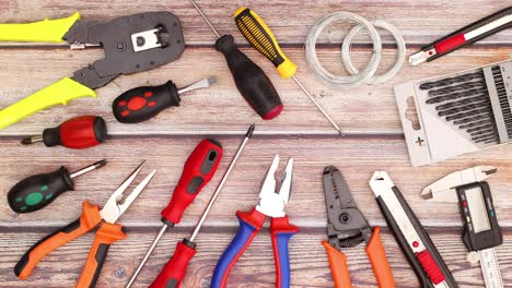 two pliers moving on the wooden table with construction and diy tools - stop motion