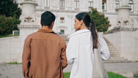 Business-couple-strolling-street-vertically-closeup.-Focused-colleagues-talking