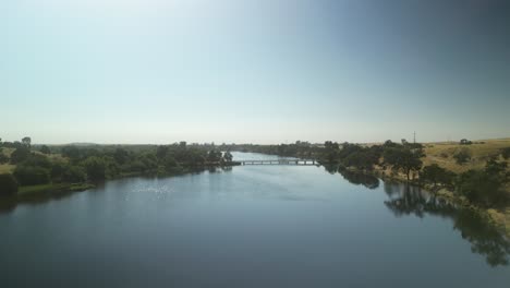 serene lake with bridge and lush green surroundings
