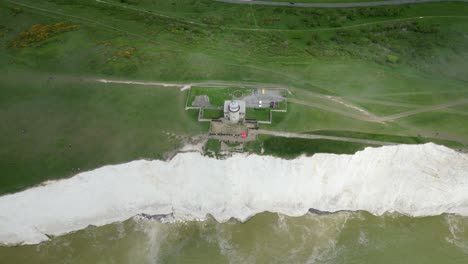 Flying-over-Belle-Tout-Lighthouse,-white-cliffs-and-sea