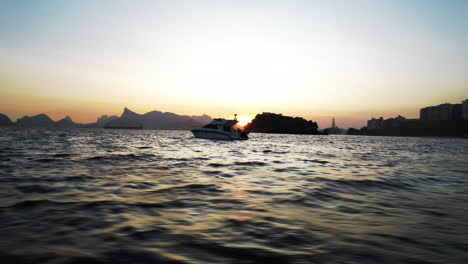 Vista-Cinematográfica-De-Un-Yate-Navegando-En-El-Mar-Al-Atardecer,-Río-De-Janeiro,-Brasil.