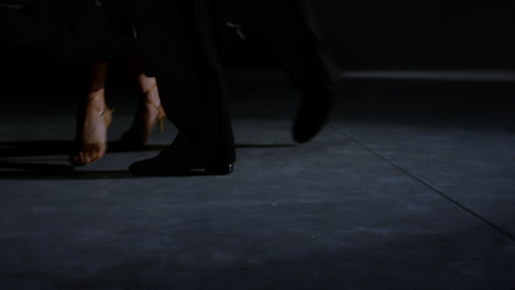 ballroom couple feet moving on stage. unrecognizable man woman legs dancing.