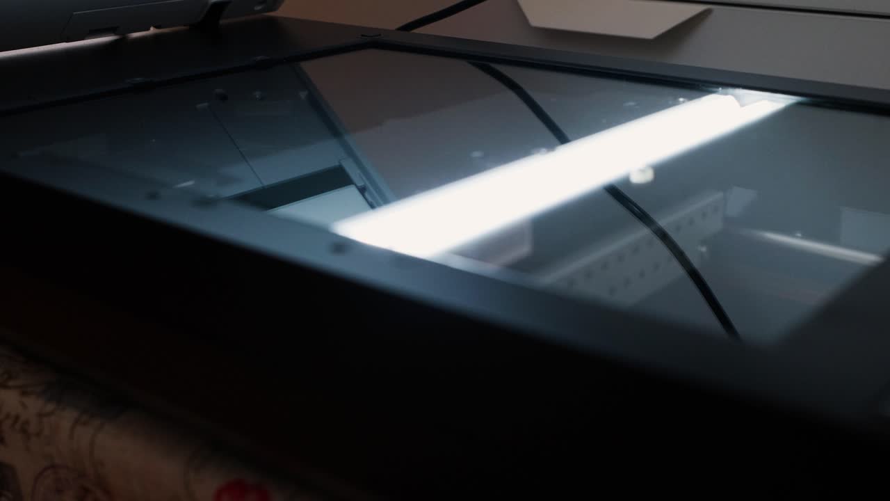 Scanner bed with glass surface and internal light bar during a document scanning process