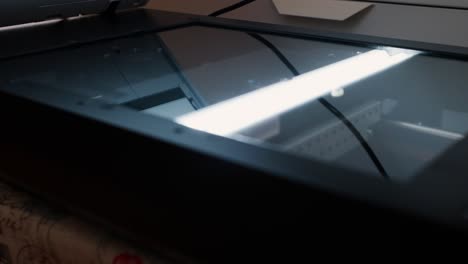 scanner bed with glass surface and internal light bar during a document scanning process