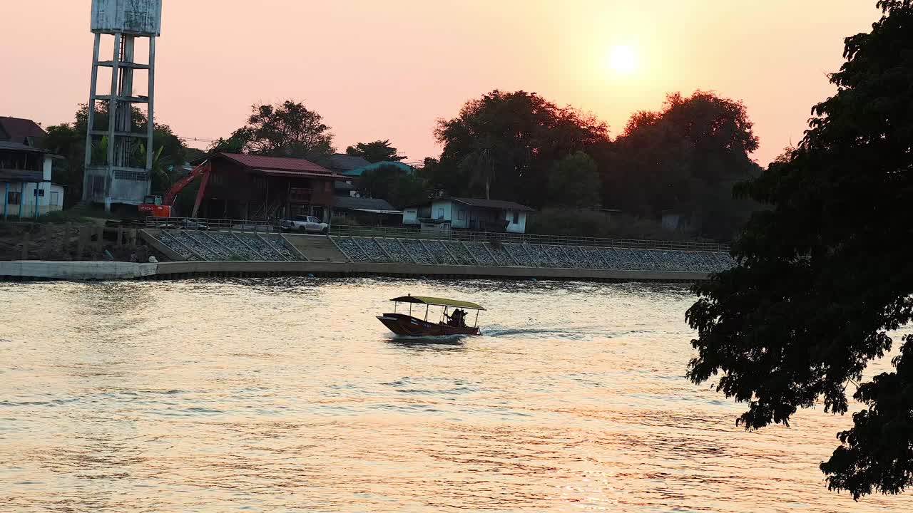 한 배가 해가 지면 강을 가로질러 이동합니다.