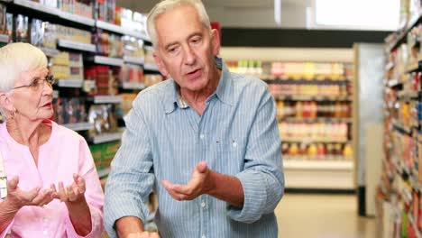 una pareja de mayores discutiendo en el supermercado.