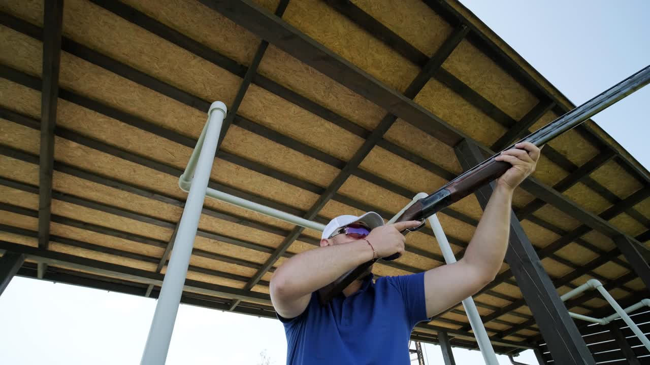 un deportista dispara con una escopeta de doble cañón, un campo deportivo para una prueba de tiro está disparando a un esquete volador