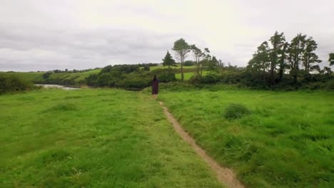 Pretty-girl-walking-in-a-green-landscape