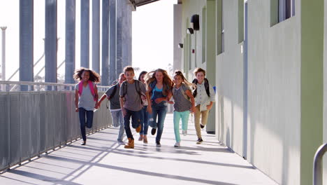 Niños-De-Escuela-Primaria-Corriendo-Hacia-La-Cámara-En-El-Pasillo-De-La-Escuela