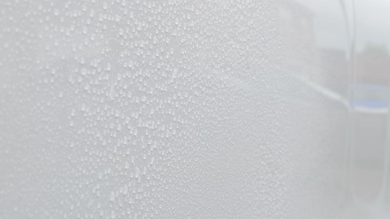 Close up of fine water beading on white paint vertical surface