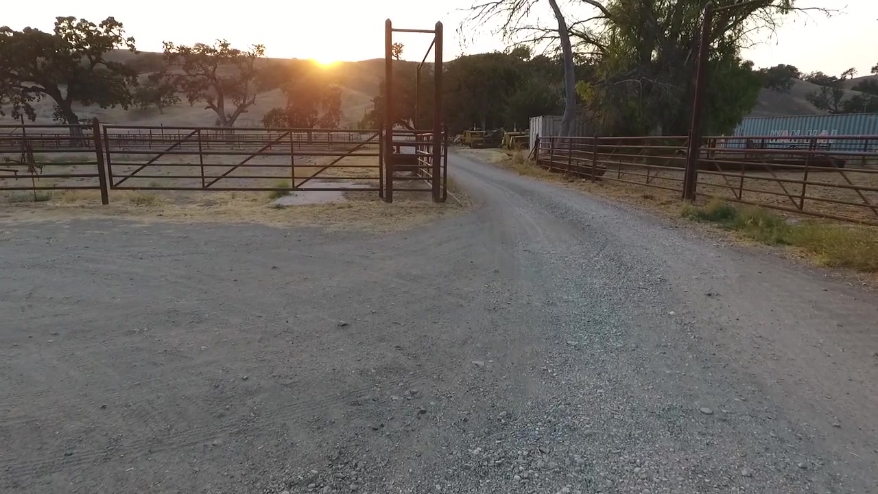 Dron sobrevolando la sede del rancho rodeado de equipo antiguo, graneros y corrales.