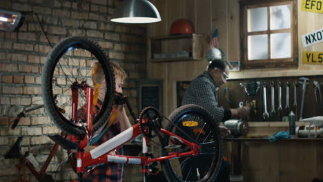 grandfather and grandson repairing a bicycle in a garage