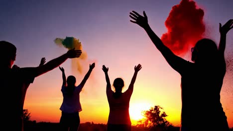 silhouette of people celebrating sunset with colorful powder