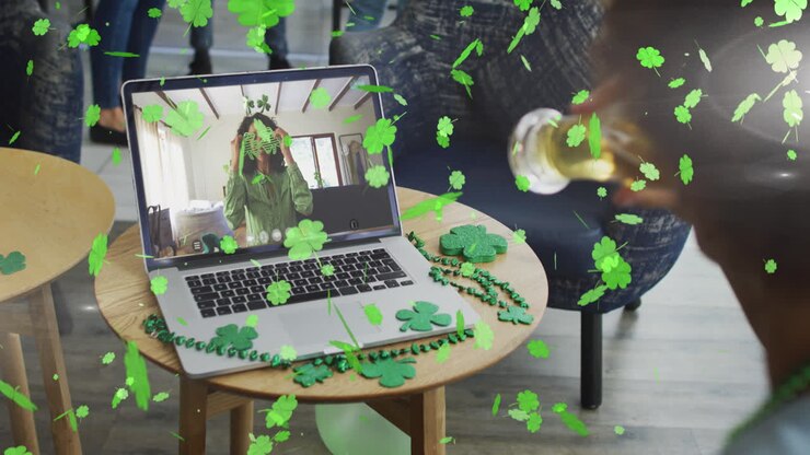 Foglie di trifoglio che cadono con donna che beve birra mentre fa una videochiamata su laptop in un bar.