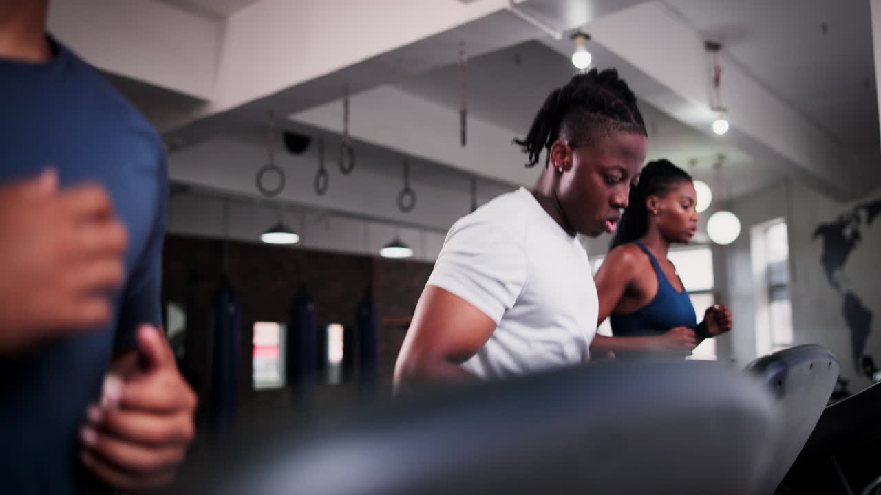 personas corriendo en cintas de correr en el gimnasio