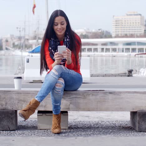 Mujer-Joven-Sentada-En-Un-Banco-En-La-Ciudad