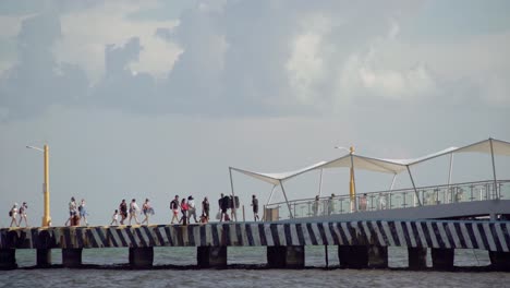 gente caminando en el muelle en un hermoso y soleado día en cancún, méxico