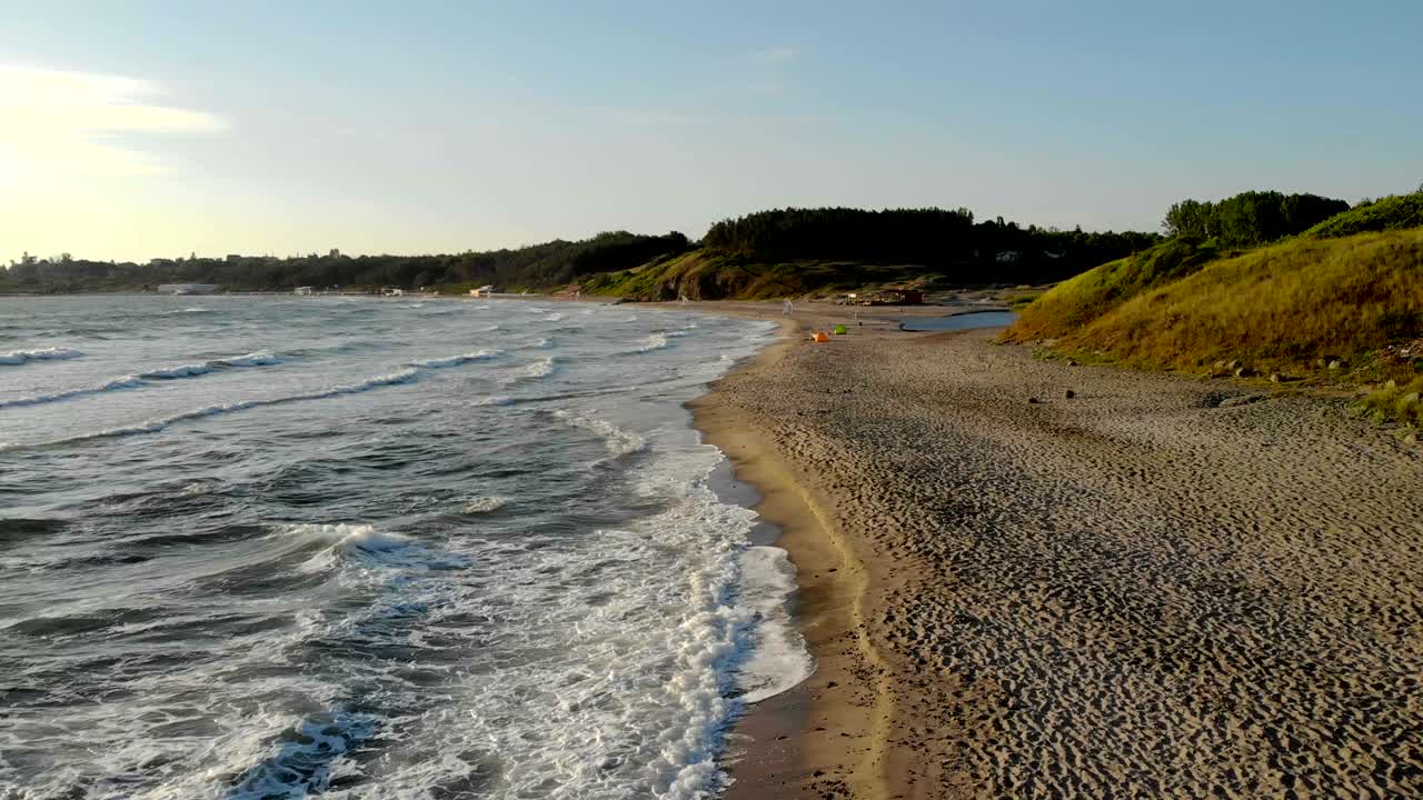 Waves crashing on sand at sunrise during vacation at Bulgaria.