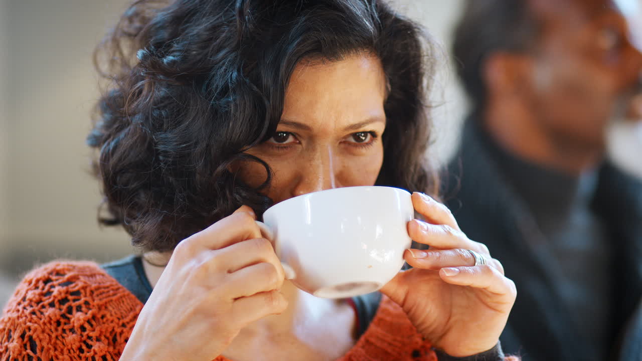 커피 ⁇ 에서 테이블을 둘러싼 친구들을 만나는 중년 여성