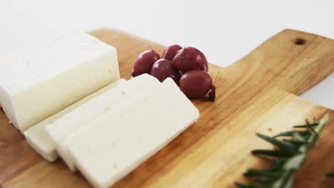 rebanadas de queso con aceitunas rojas y hierbas de romero