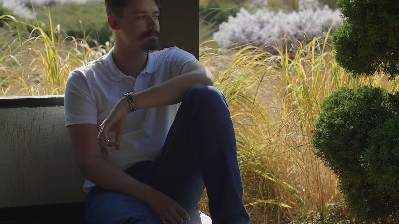 Modello maschile con barba, all'aperto e sotto il sole.