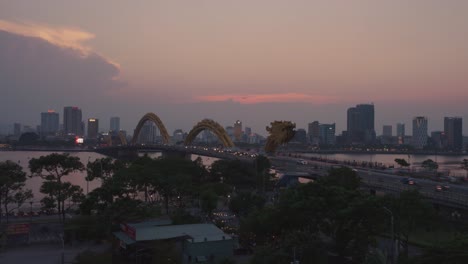 el lapso de tiempo del icónico puente del dragón cau rong, el tráfico y el horizonte durante la puesta de sol en danang, vietnam