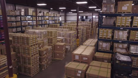aerial of boxes stacked on floor and shelves in industrial warehouse