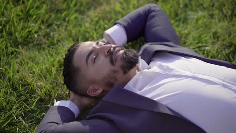 happy businessman relaxing on green lawn