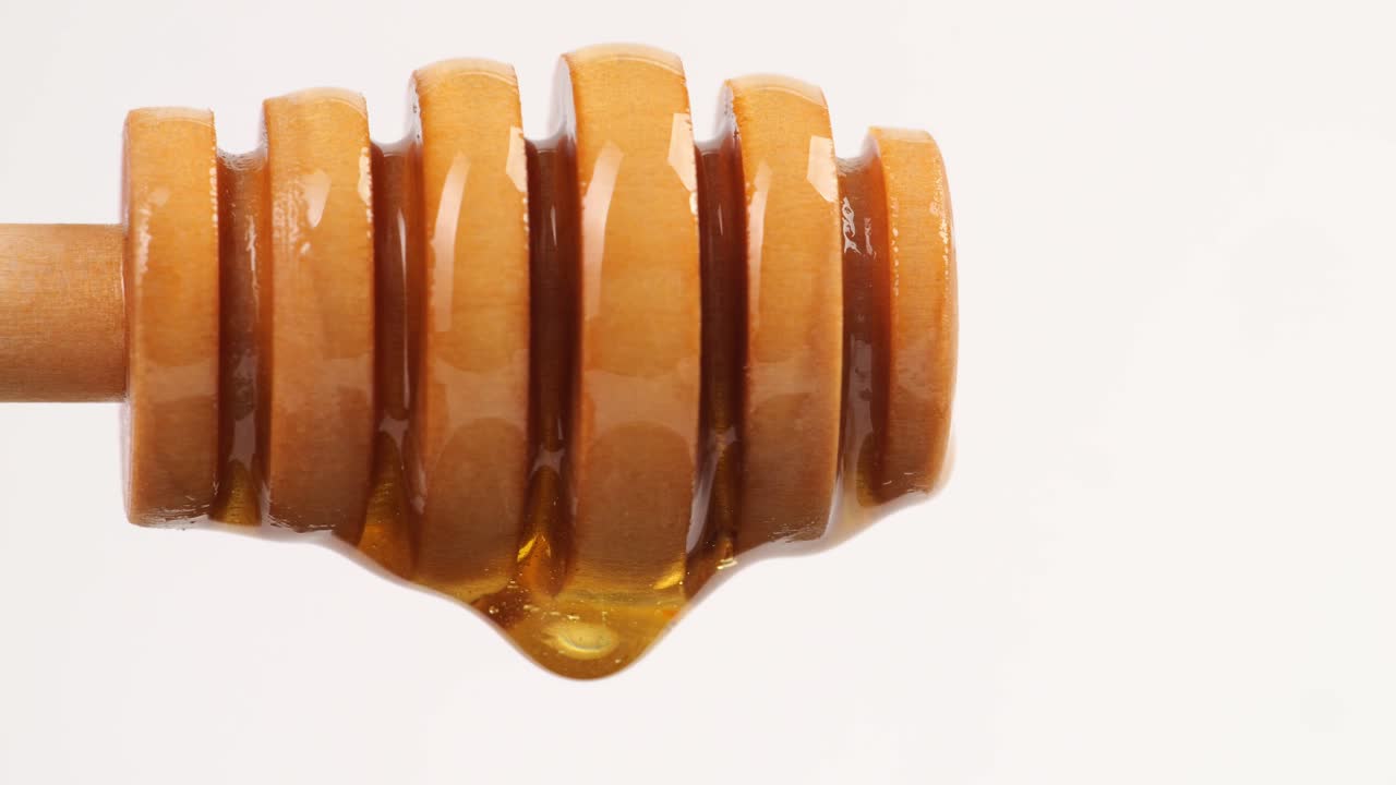 Honey Dripping From Honey Dipper On The White Background. Healthy Organic Thick Honey Closeup, Sweet Honey Dessert 4K