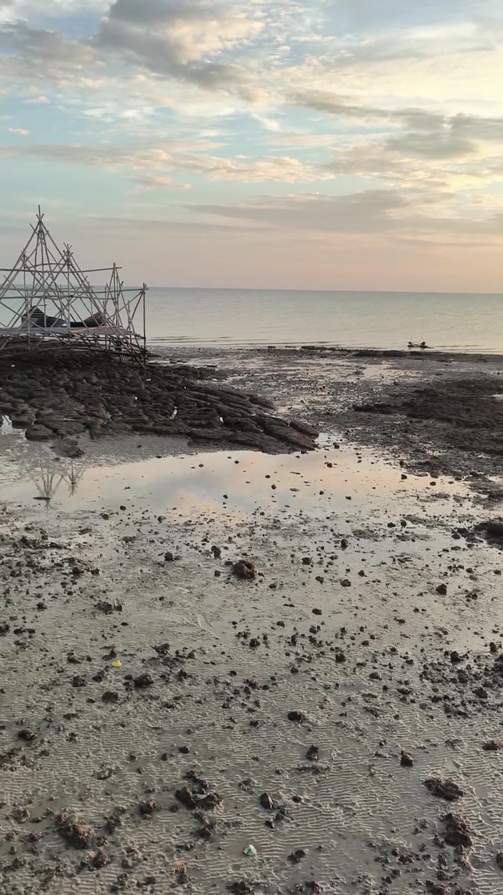 Peaceful Beach at Low Tide with Calm Sea and Cloudy Sky
