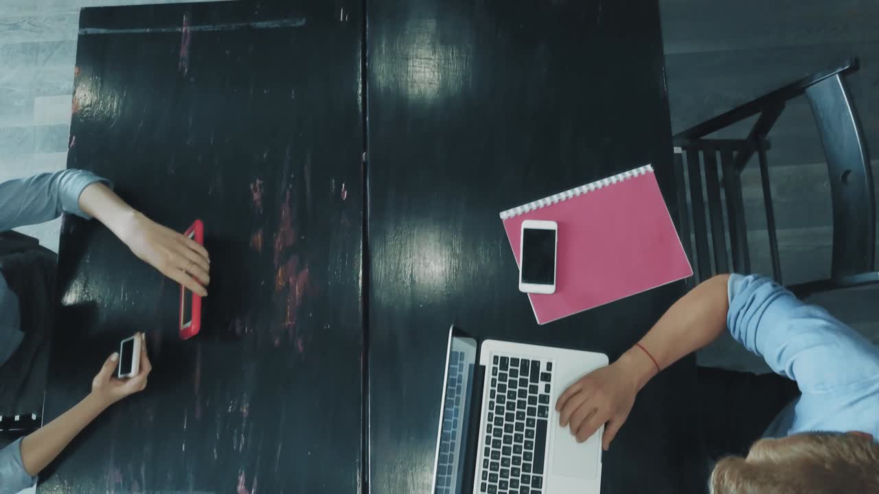 escritorio de un equipo de negocios creativo que trabaja en portátiles y se comunica utilizando teléfonos inteligentes en la oficina. coworking. vista superior