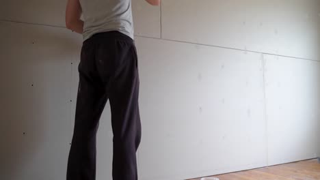 person apply putty structure on plasterboard to hide screw holes