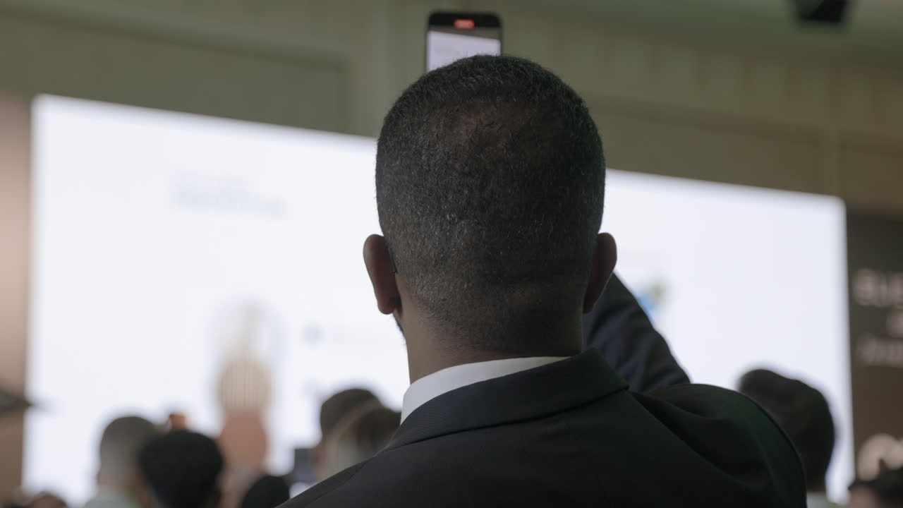 Uomo che scatta una foto a una conferenza aziendale.