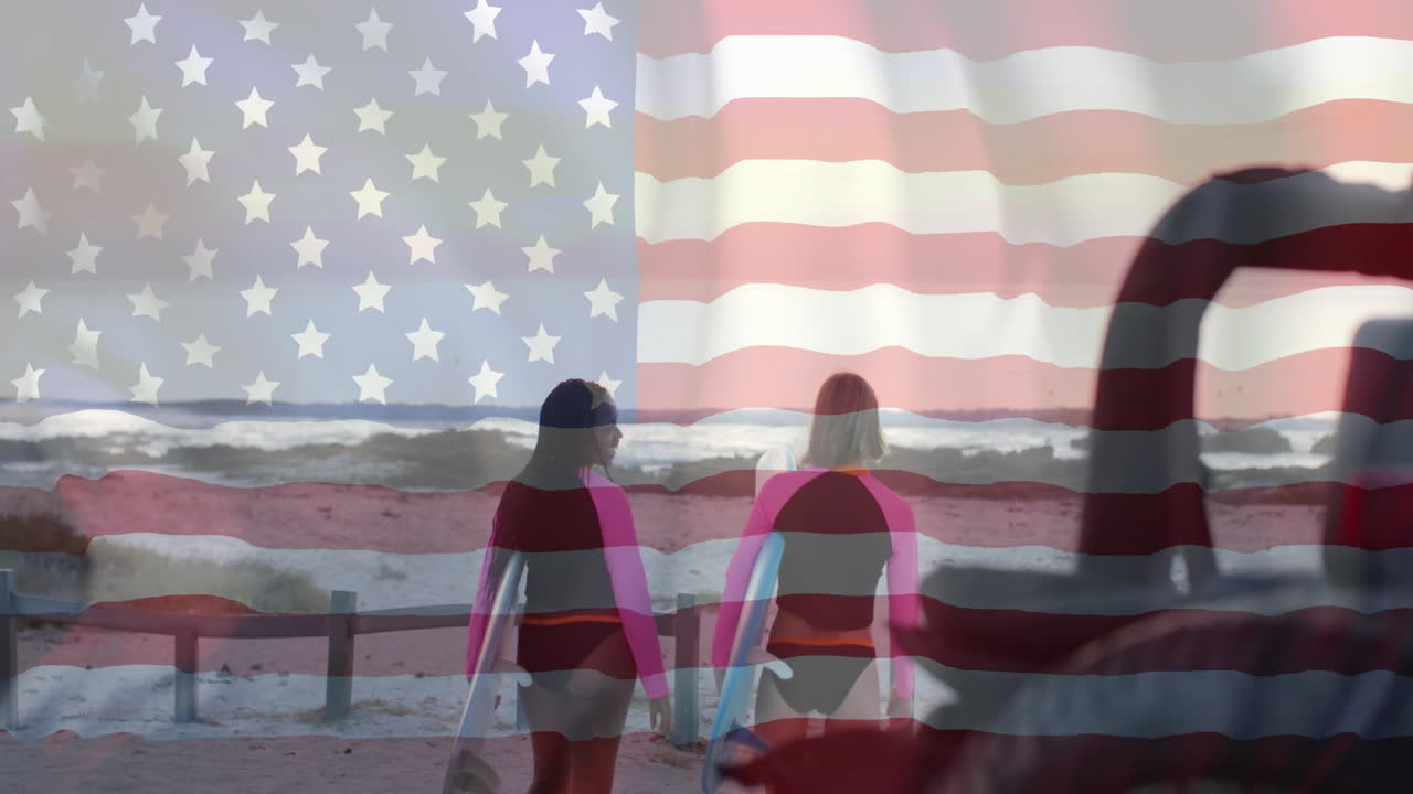 Animation of flag of usa over happy diverse women with surfboards on beach in summer