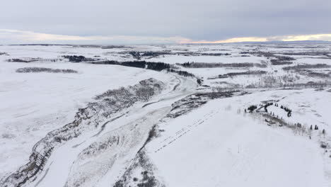 Wide-landscape-of-prairies-in-Alberta,-Canada-frozen-from-a-drone