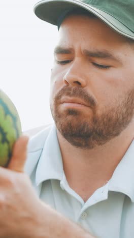 farmer examining watermelon in greenhouse