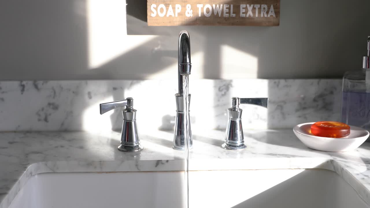 Uomo che apre il rubinetto in un bagno soleggiato in 4K