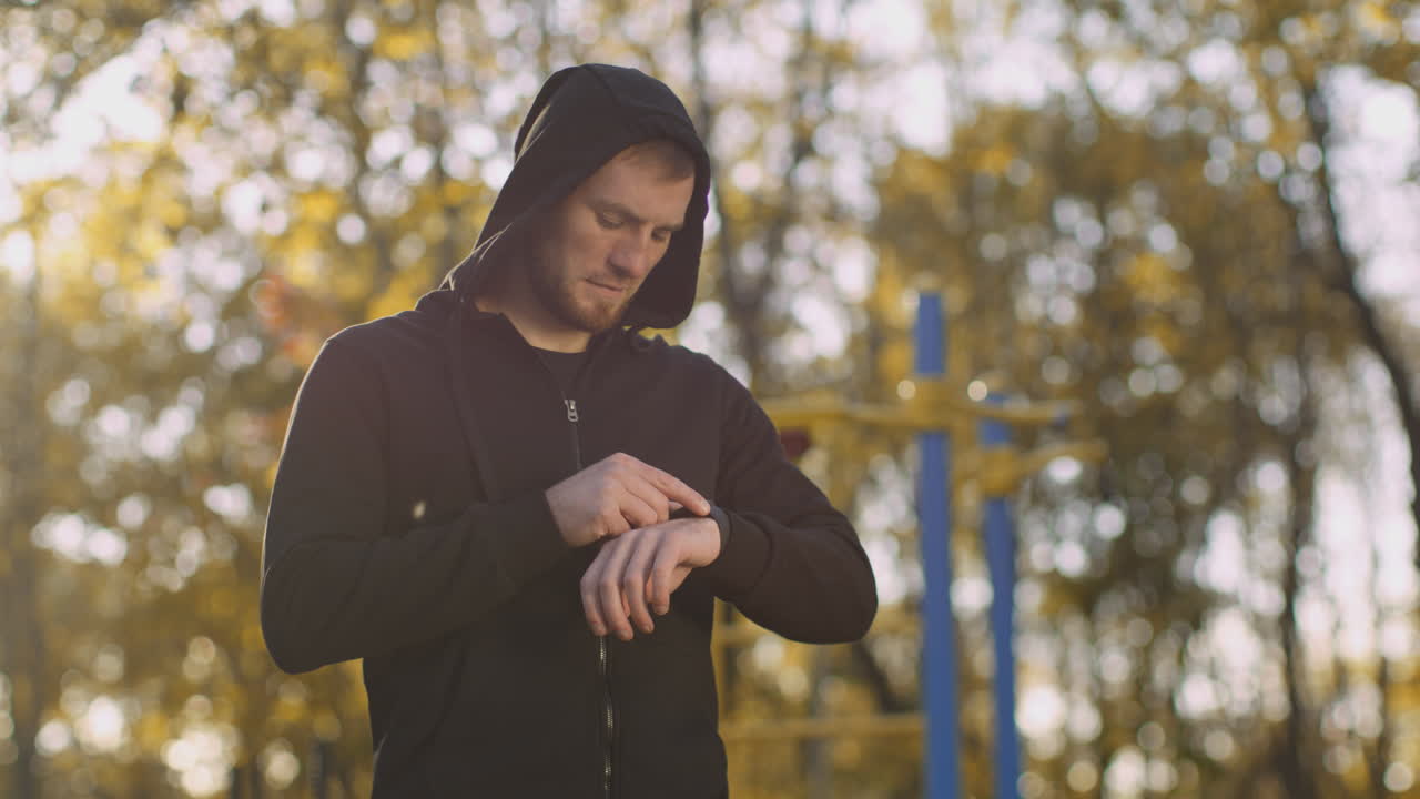 Man Checking Smartwatch in Park