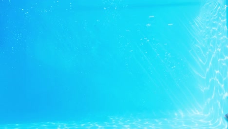 Pretty-brunette-swimming-underwater-in-pool