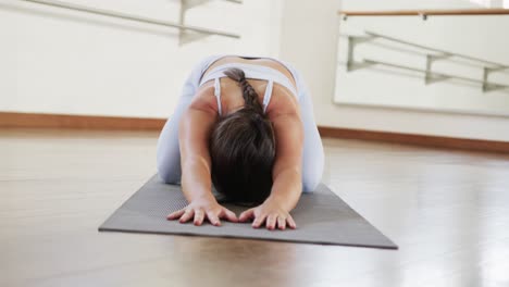 Mujer-Caucásica-Enfocada-Practicando-Yoga-En-El-Gimnasio,-Cámara-Lenta