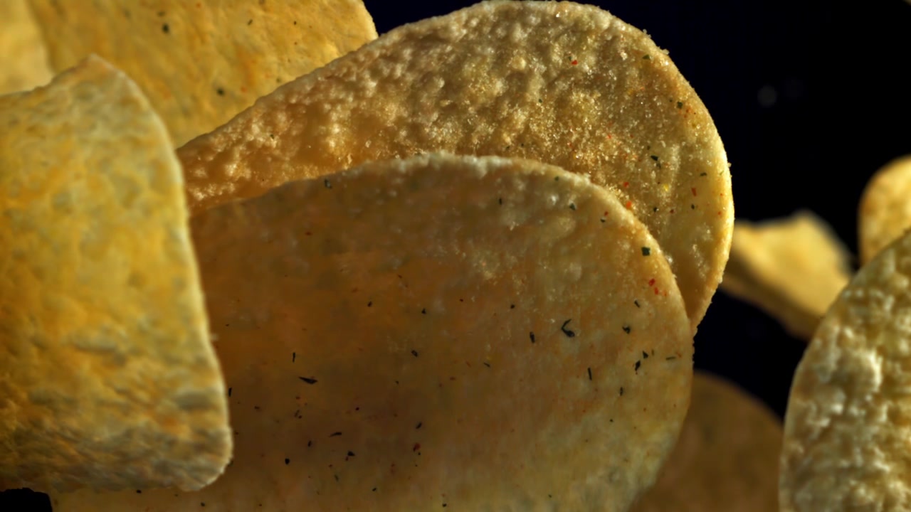 Primo piano di patatine condite su sfondo scuro