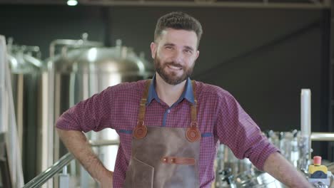 young male brewer works at a modern brewery