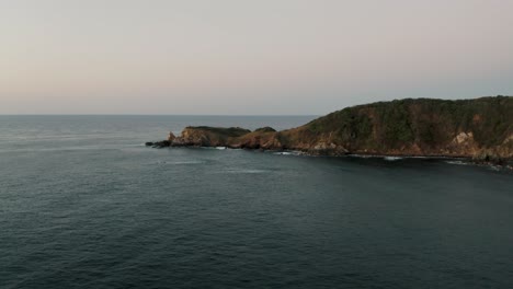 Flying-over-the-beautiful-rocky-islands-near-Mazunte,-Oaxaca-at-sunset