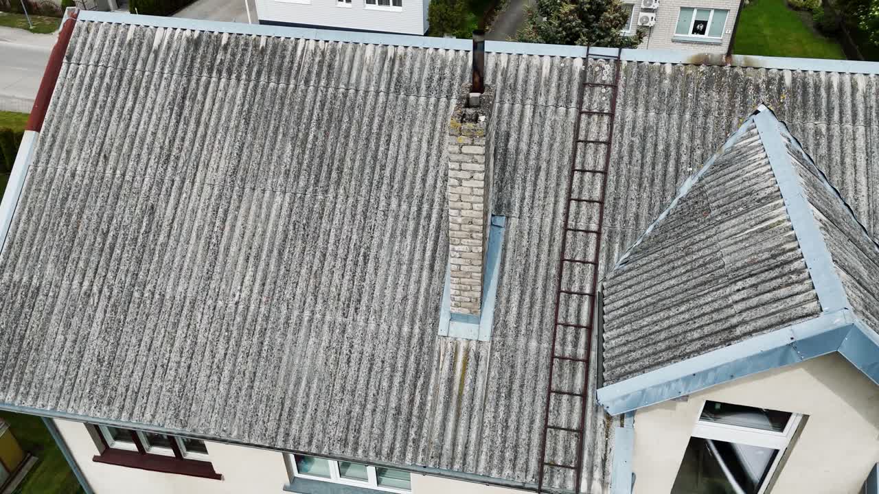 Old house roof with chimney, showing clear signs of fire damage from previous blaze