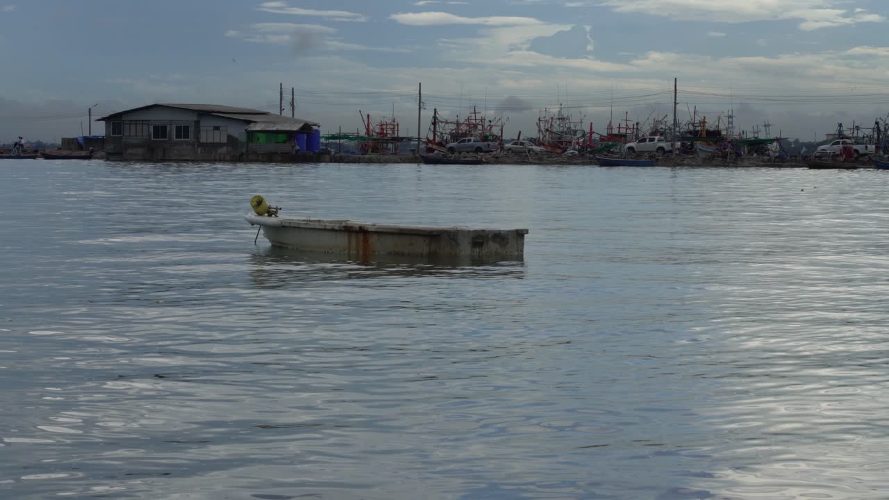 vista serena de un pequeño barco de pesca contra el fondo de una casa está anclado cerca del muelle de barcos de pesca na kluea, pattaya, tailandia