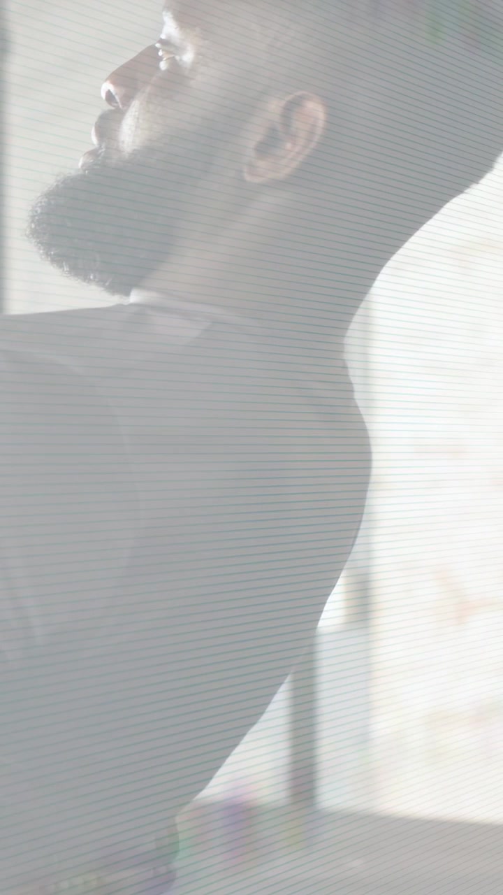Vertical video: Starting leaned-back, bearded man pulling and rotating torso right for exercise