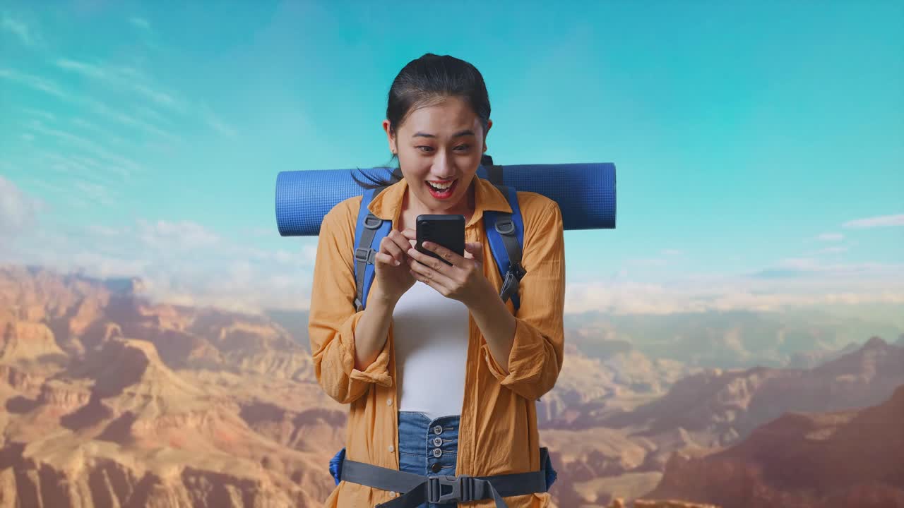 Asian Female Hiker With Mountaineering Backpack Looking At The Smartphone And Screaming Goal Celebrating The Success While Traveling At The Top Of Mountain