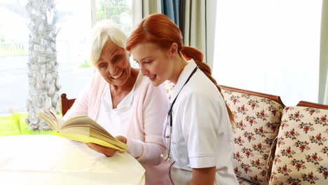 enfermera y una anciana leyendo un libro juntos