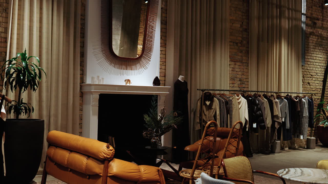 Elegant boutique interior featuring designer clothing, warm lighting, and a cozy lounge area. Premium retail space with modern decor, neutral tones, and refined atmosphere